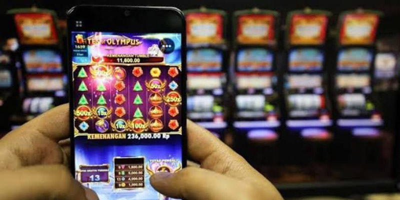 Ilustrasi pemain judi online menggunakan laptop dan ponsel
