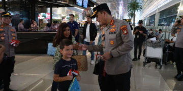 Kapolresta Bandara Soekarno-Hatta Kombes Pol Ronald FC Sipayung membagikan bendera Merah Putih kepada penumpang di Bandara Soetta, Tangerang, Banten.