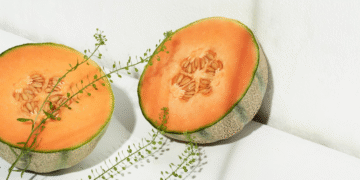 Alt: Melon oranye segar dipotong setengah dengan biji terlihat