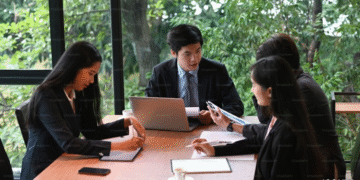 Chinese team collaborating in a modern office with laptops