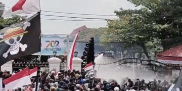Aparat kepolisian menembakkan water cannon ke arah massa aksi di depan Kantor Bupati Pati, Rabu (13/8/2025).