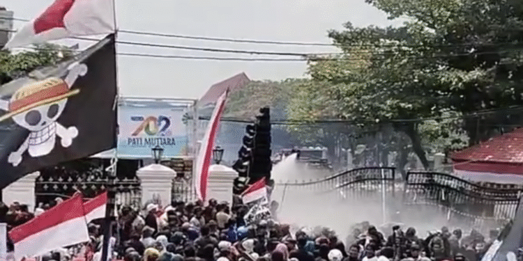 Aparat kepolisian menembakkan water cannon ke arah massa aksi di depan Kantor Bupati Pati, Rabu (13/8/2025).