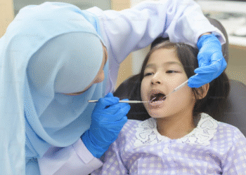 Dokter gigi memeriksa gigi anak di ruang perawatan untuk mendukung kesehatan gigi dan rahang sejak dini.