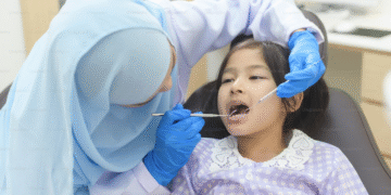 Dokter gigi memeriksa gigi anak di ruang perawatan untuk mendukung kesehatan gigi dan rahang sejak dini.