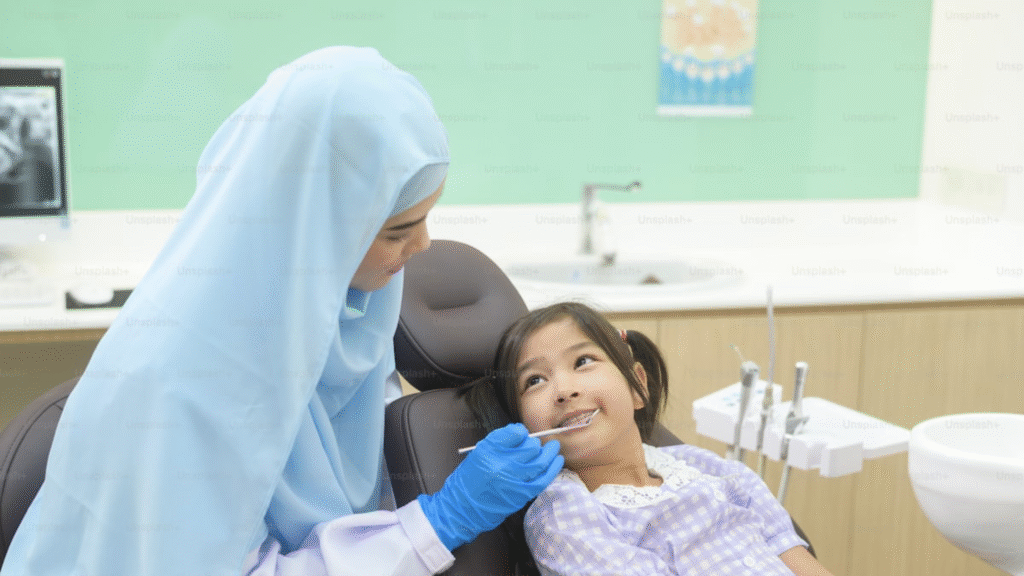 Dokter gigi memeriksa gigi anak di ruang perawatan untuk mendukung kesehatan gigi dan rahang sejak dini.