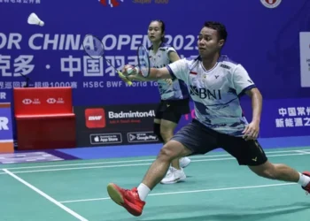 Rehan Naufal Kusharjanto mengembalikan kok dalam pertandingan bulutangkis.